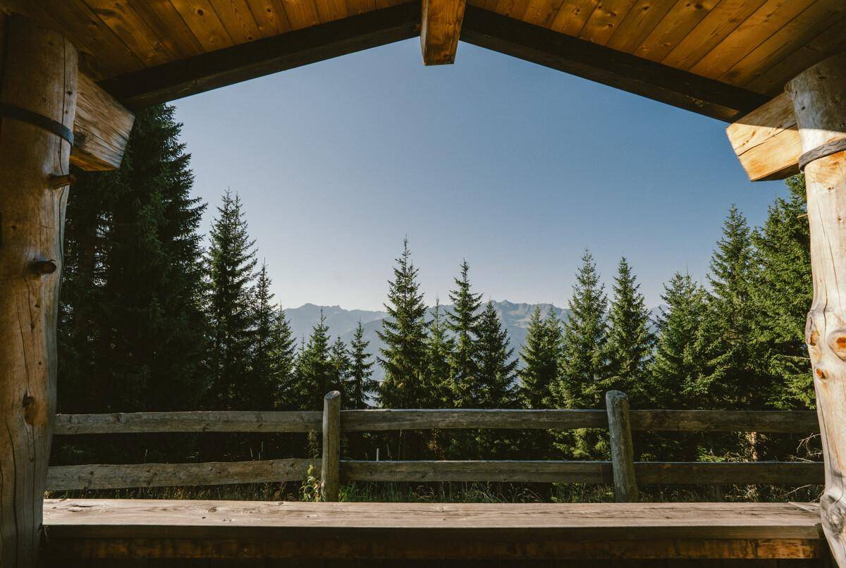 Panoramablick von der überdachten Loggia auf die majestätischen Berge und dichten Wälder.