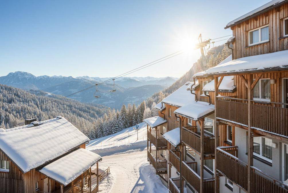 Winterlicher Ausblick auf die verschneiten Chalets, den Skilift und die umliegenden Berge.