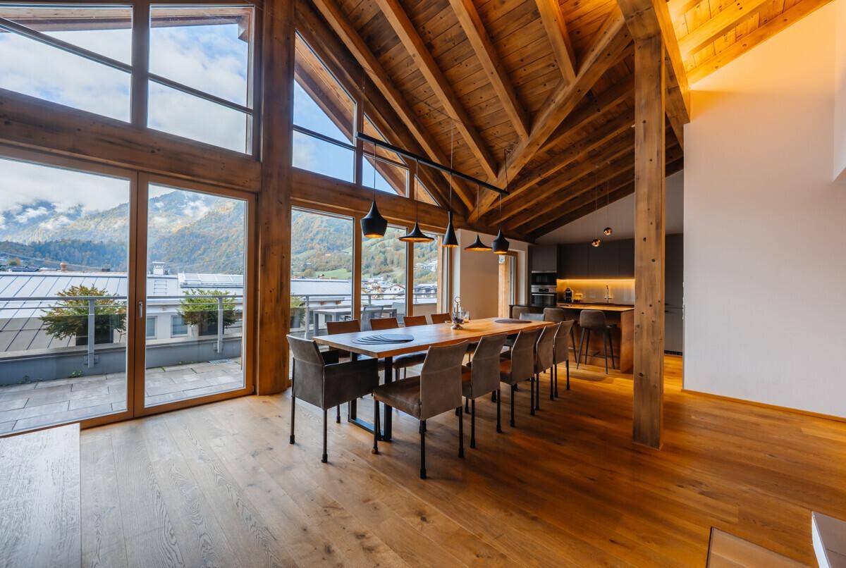 Heller Wohn- und Essbereich mit Holzboden, hohen Decken und Zugang zur Terrasse.