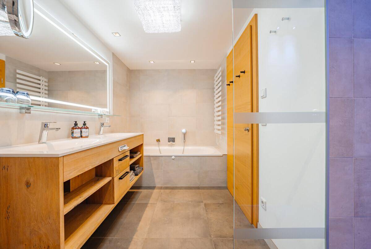 Modernes Badezimmer mit Doppelwaschbecken, Badewanne und separater Dusche.