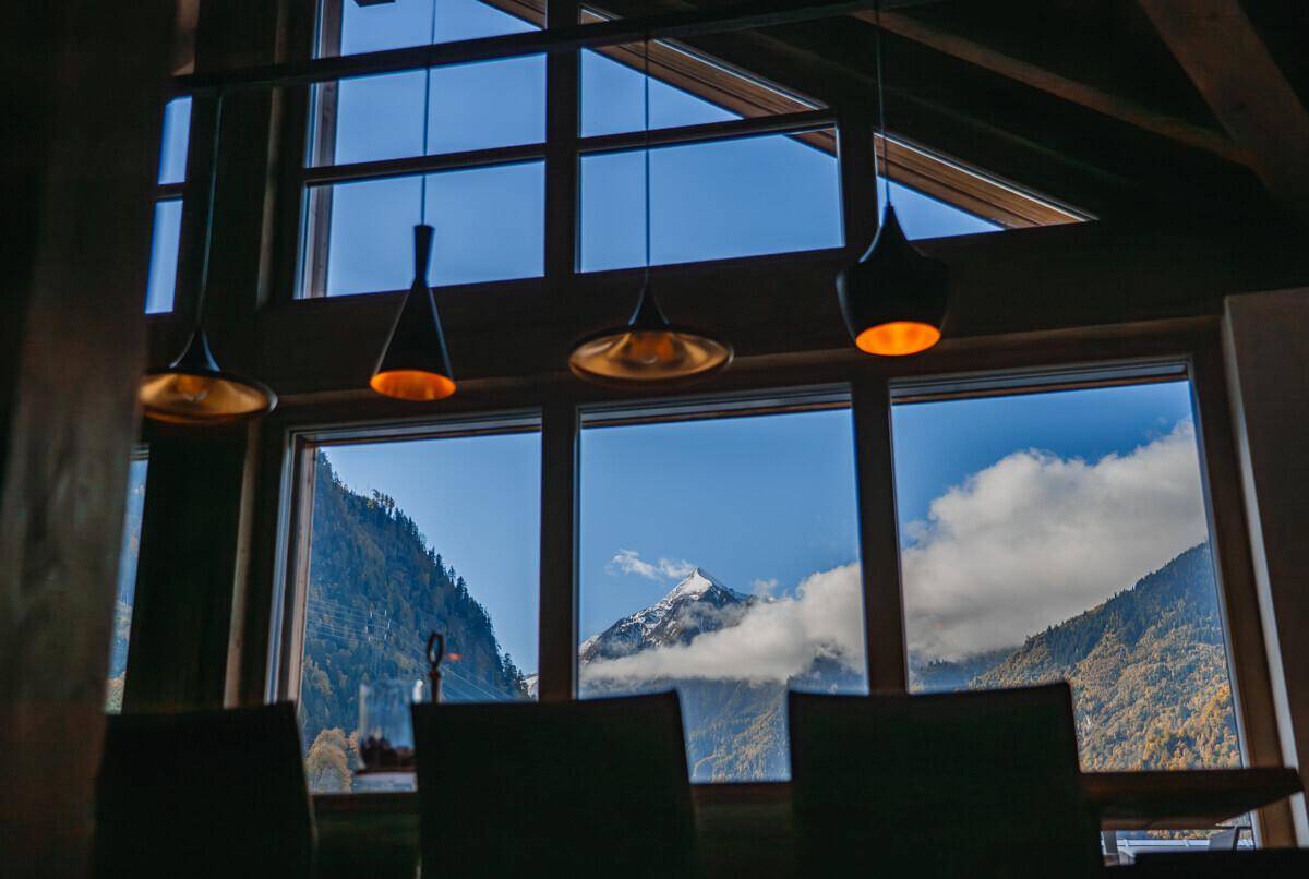 Essbereich mit stilvollen Pendelleuchten und atemberaubendem Blick auf die schneebedeckten Berge.