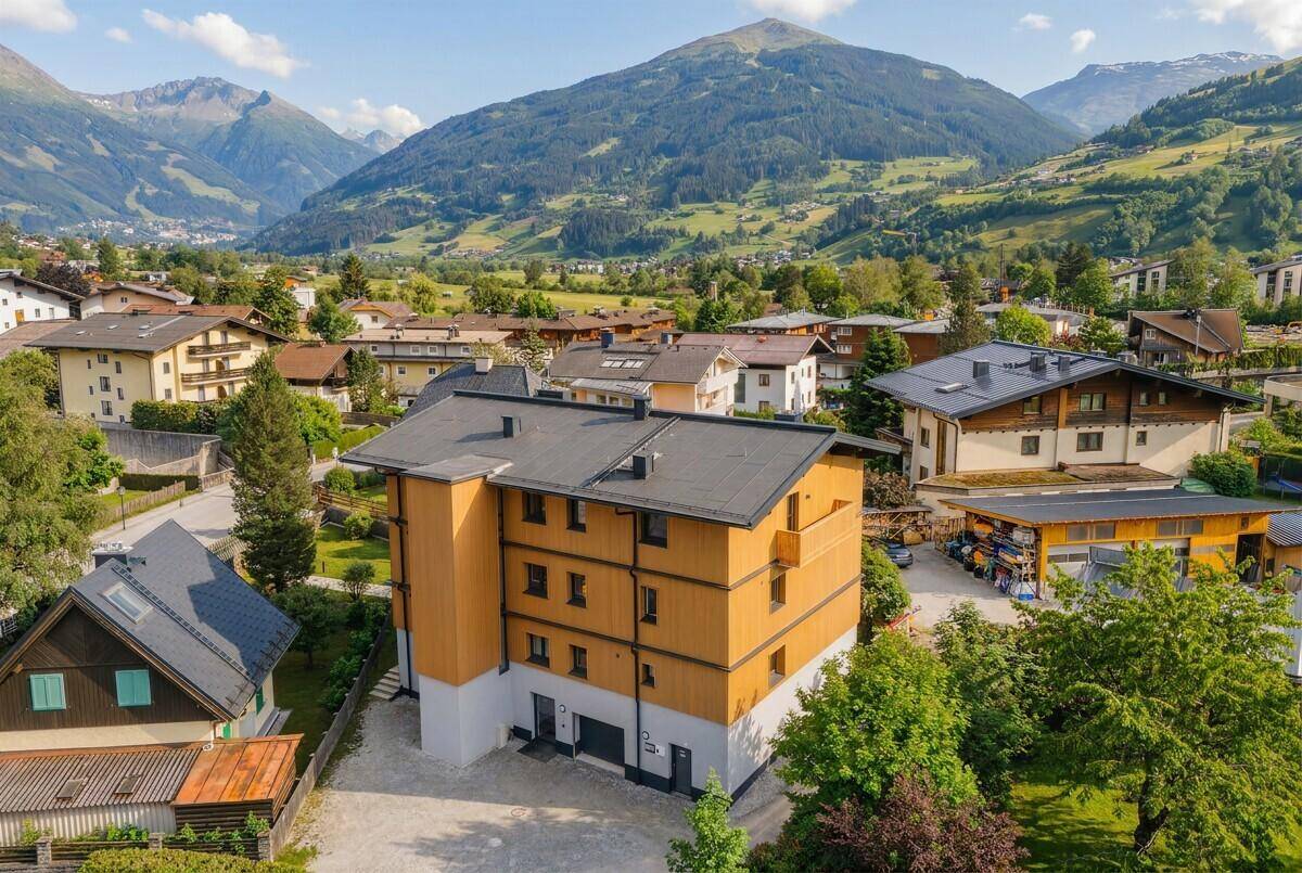 Gebäude in alpiner Umgebung mit moderner Architektur und umliegender Natur, unter blauem Himmel.