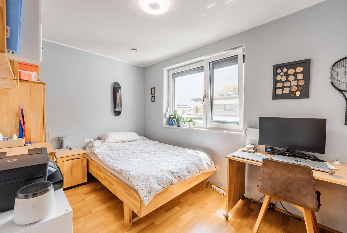 Gemütliches Schlafzimmer mit Einzelbett, Schreibtisch und hellem Fenster.