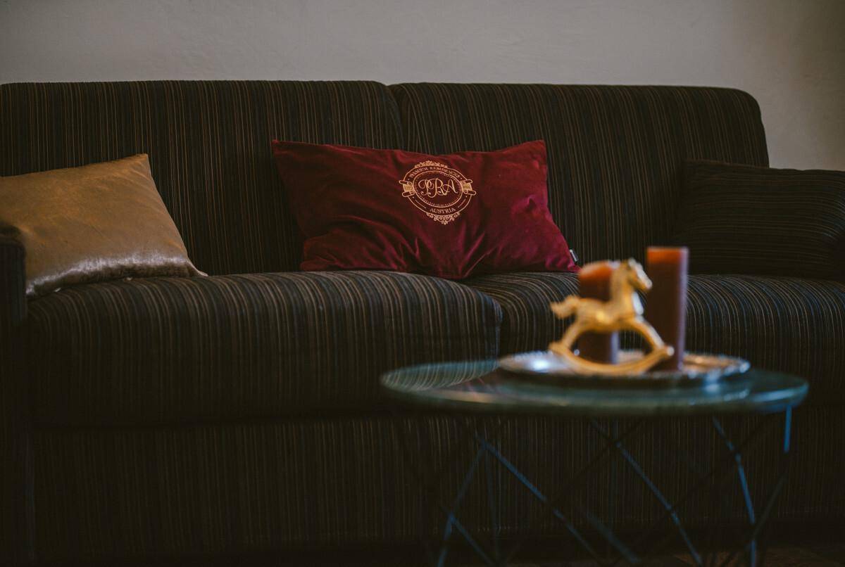 Gemütliches Sofa mit Kissen und einem kleinen Beistelltisch in warmen Farbtönen.