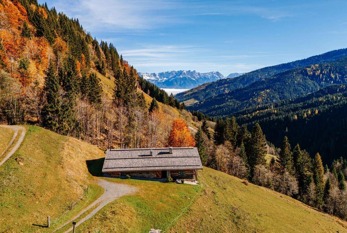 Panoramablick auf das Chalet in der Berglandschaft mit weitem Talblick und schneebedeckten Gipfeln.