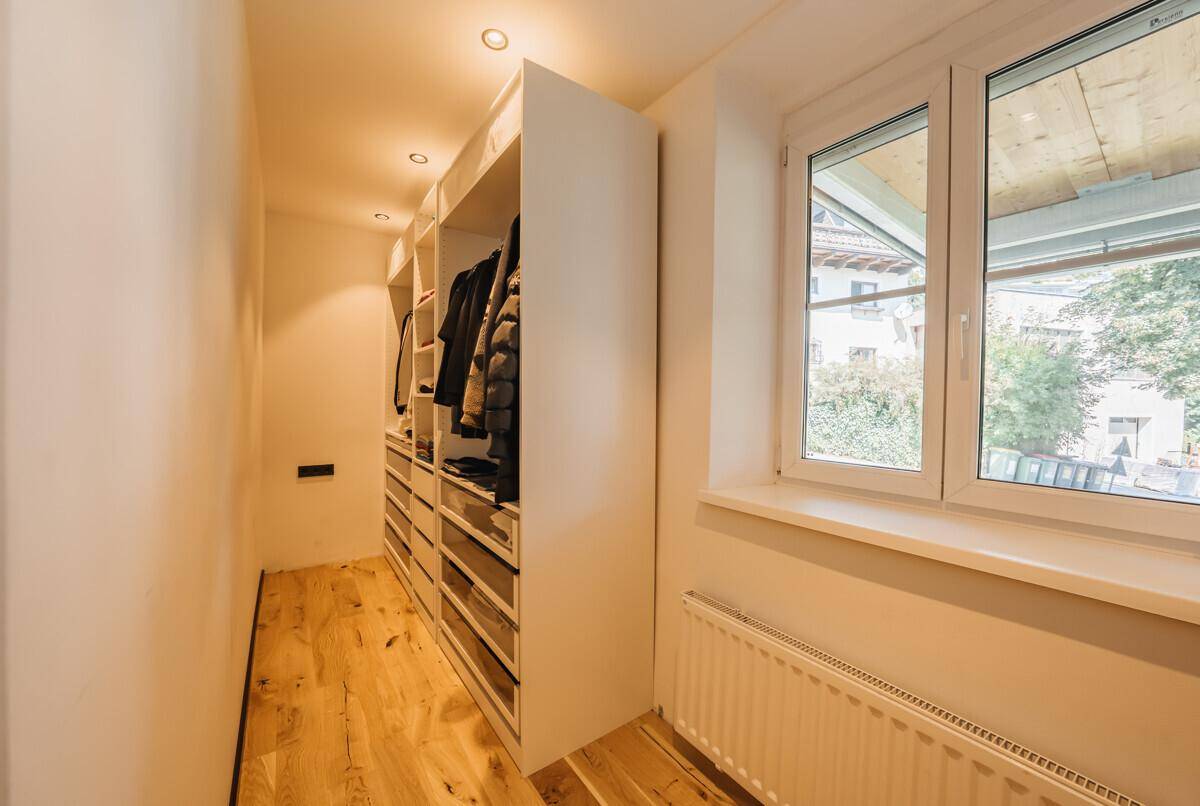 Praktischer begehbarer Kleiderschrank mit integrierten Regalen und viel Stauraum.