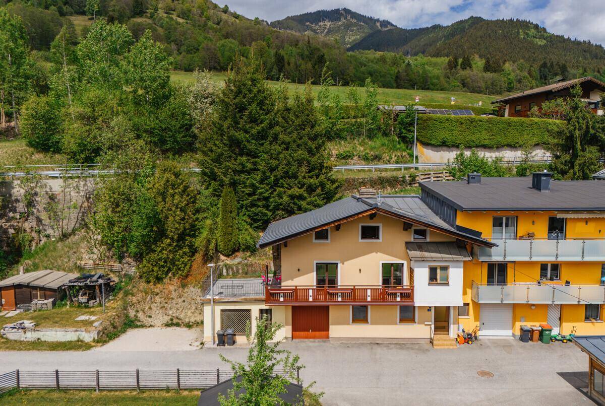Übersicht des Hauses mit umliegender Natur, Bergen und einem kleinen Gartenbereich.