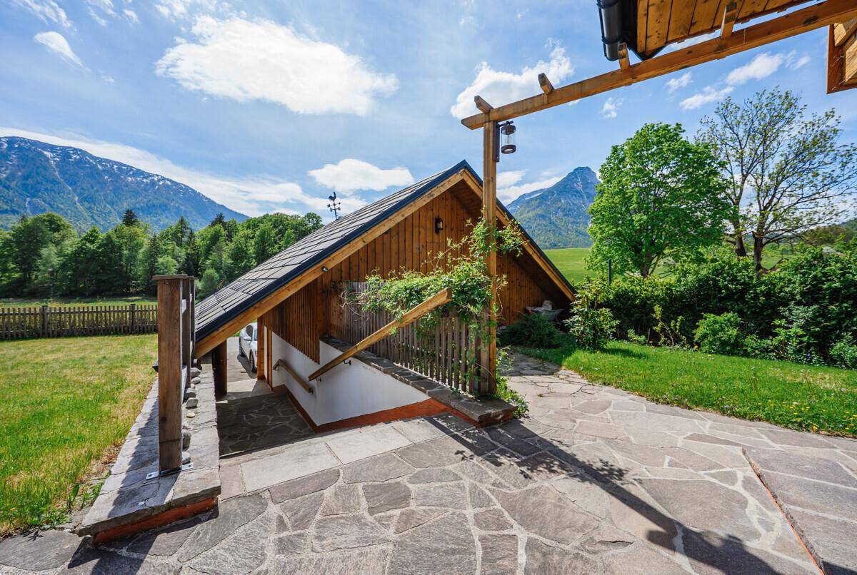 Außentreppe führt zum Kellerabgang des Hauses, umgeben von Grünflächen.