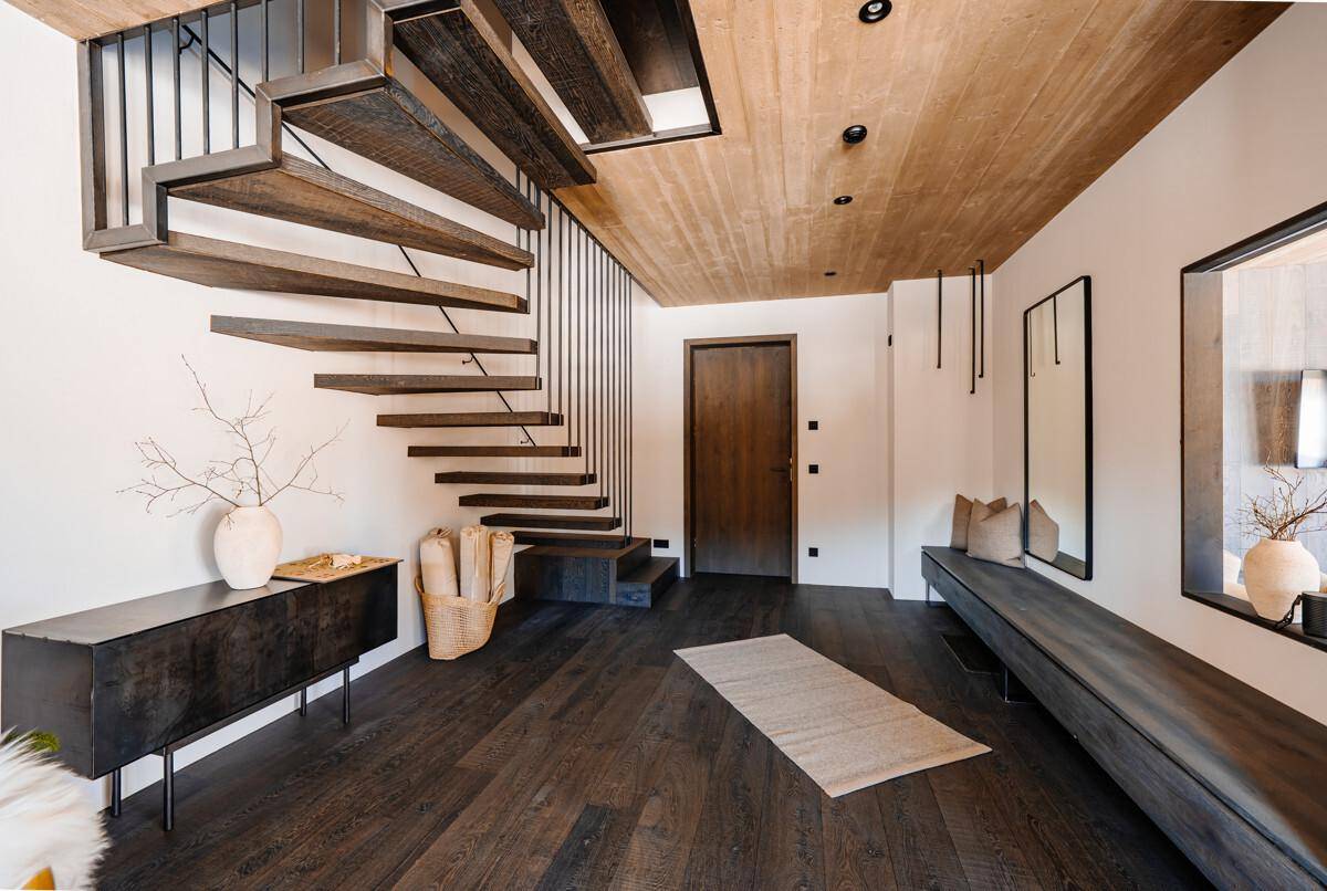Moderner Eingangsbereich mit Holztreppe, Holzboden und Garderobe.