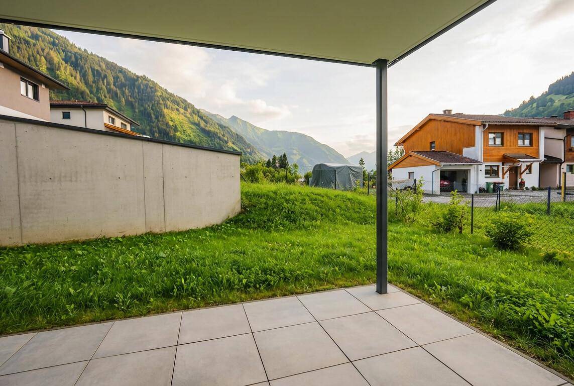 Sonniger Terrassenbereich mit Fliesen und freiem Blick auf die umliegenden Berge und Natur.