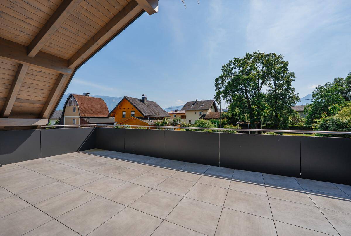 Geräumige, unmöblierte Terrasse mit Fliesenboden und weitem Blick auf die umliegende Berglandschaft.
