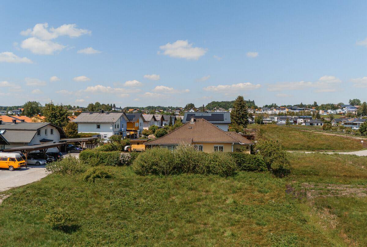 Weitläufiger Blick auf eine ländliche Wohngegend mit Häusern und viel Grün.