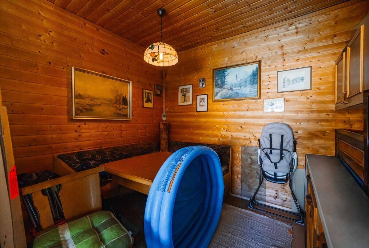 Gemütlicher Essbereich mit Holztäfelung, Eckbank und traditionellen Bildern an den Wänden.