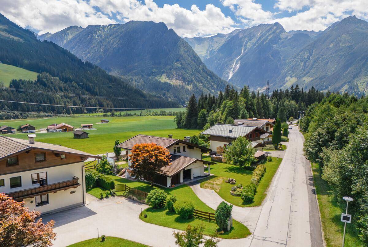 Malerische Wohngegend umgeben von majestätischen Bergen und weiten grünen Feldern.