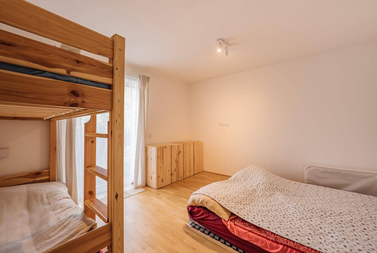 Kinderzimmer mit Etagenbett aus Holz und hellem Parkettboden, ideal für Gäste.