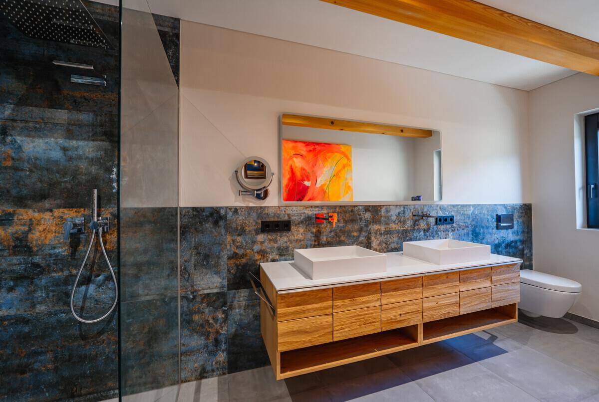 Modernes Badezimmer mit Doppelwaschbecken, begehbarer Dusche und rustikalen Fliesen.