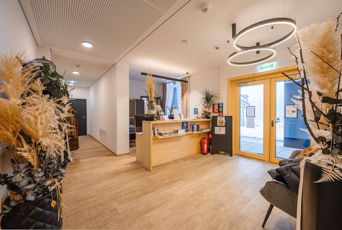 Heller und einladender Eingangsbereich mit Rezeption und moderner Dekoration.