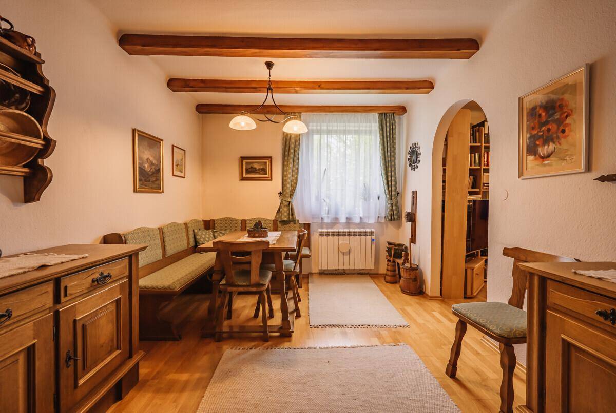 Rustikaler Essbereich mit Holzbalken, Eckbank und traditionellen Möbeln, ideal für Familienessen.