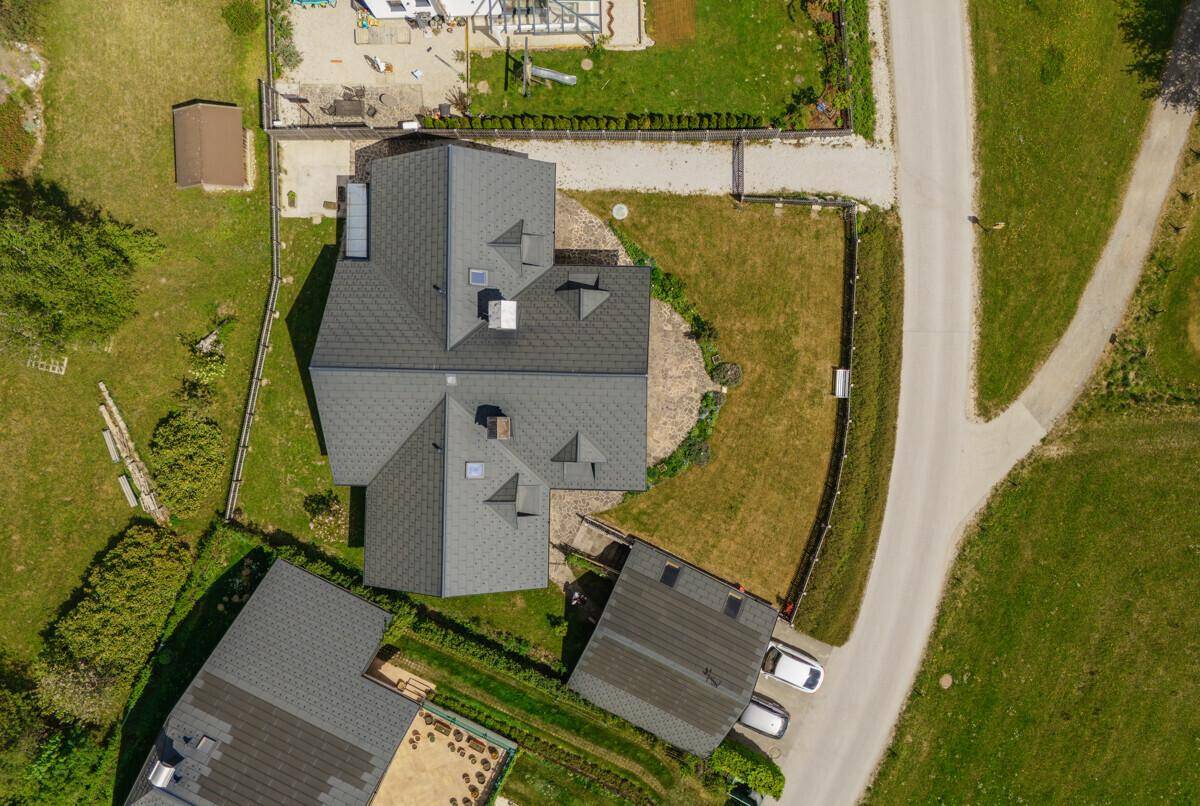 Draufsicht auf das Haus mit Satteldach und umliegendem Grundstück in ländlicher Umgebung.