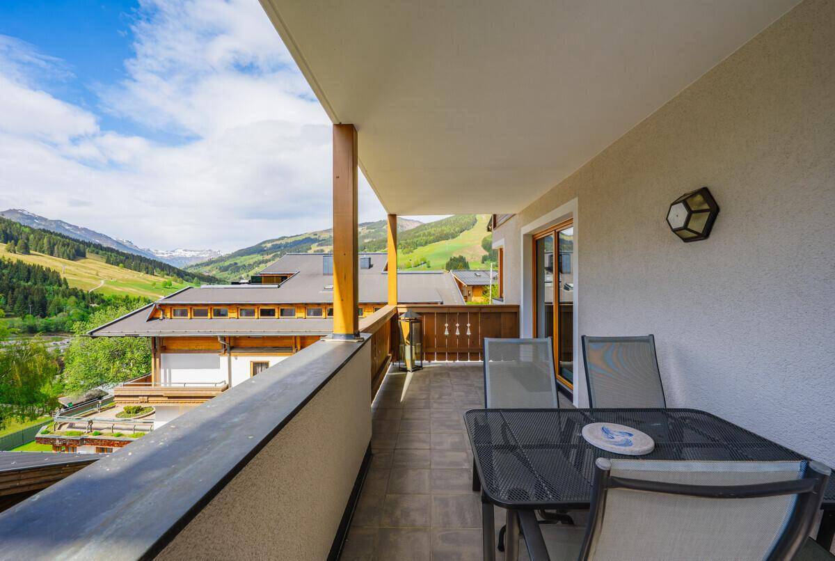 Balkon mit Gartenmöbeln und einem schönen Ausblick auf die Berglandschaft.