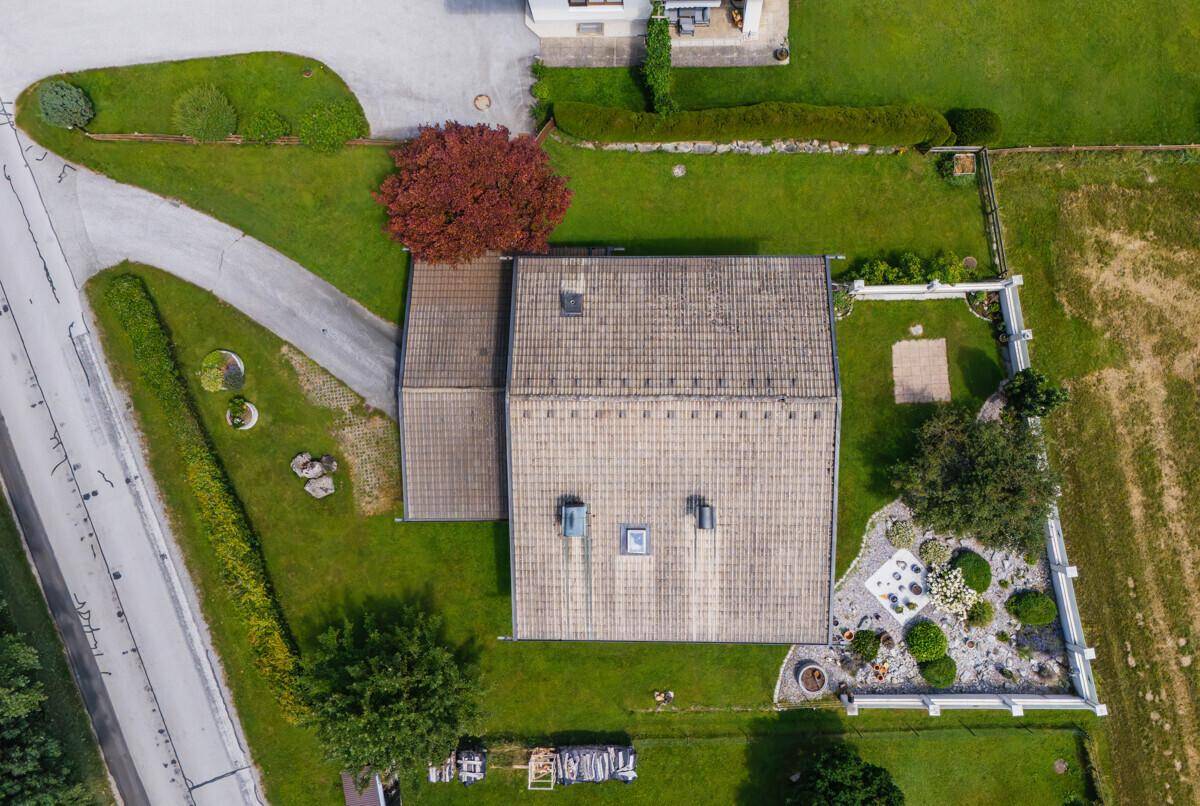 Luftaufnahme des Hauses mit Satteldach, gepflegtem Garten und angrenzender Wiese.