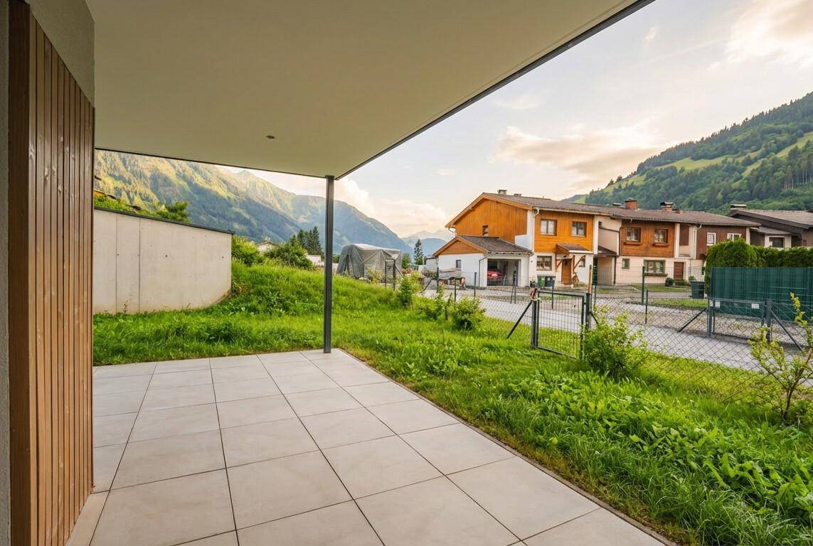 Geräumige Terrasse mit Fliesenboden und weitem Blick auf die grüne Berglandschaft.