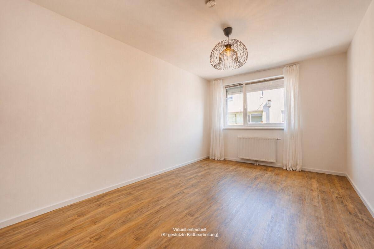 Heller, unmöblierter Raum mit Laminatboden und Fenster, vielseitig nutzbar für Schlaf- oder Arbeitszimmer.