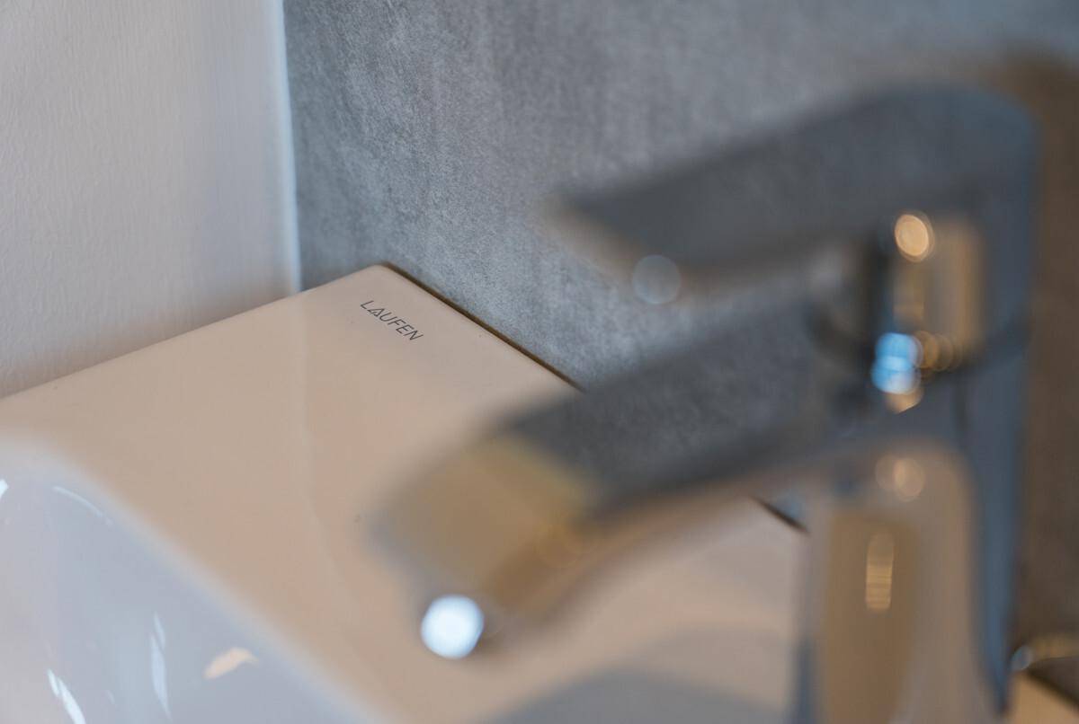 Nahaufnahme eines modernen Waschbeckens der Marke Laufen mit elegantem Wasserhahn.