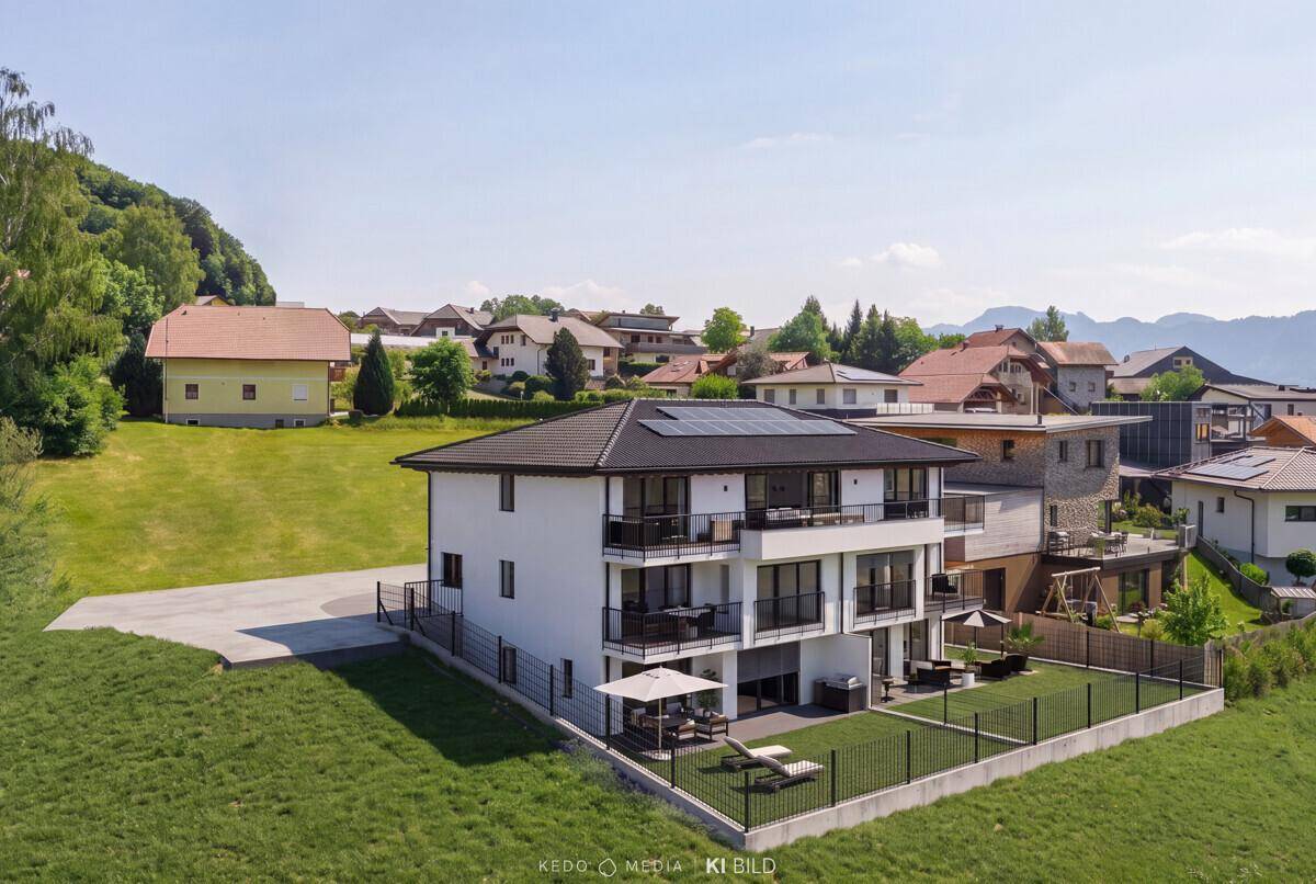 Moderne Wohnanlage mit Balkonen und Gartenbereich, eingebettet in eine ländliche Umgebung.