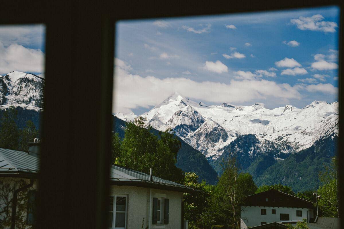 Spektakulärer Blick auf schneebedeckte Berge durch ein Fenster.