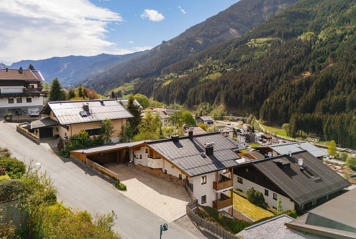 Weitläufige Ansicht eines Bergdorfes mit traditionellen Häusern und einer malerischen Bergkulisse.