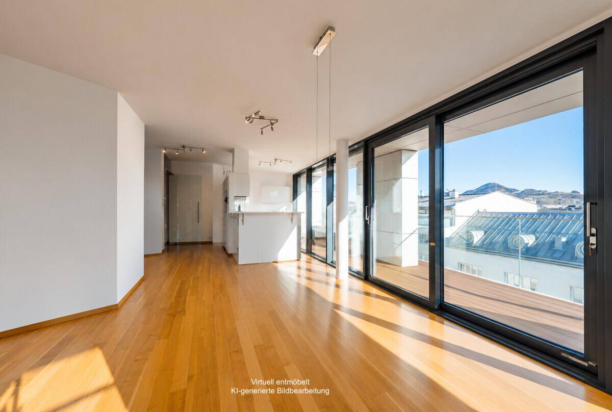 Heller, unmöblierter offener Wohnbereich mit Holzboden und Zugang zur Terrasse.