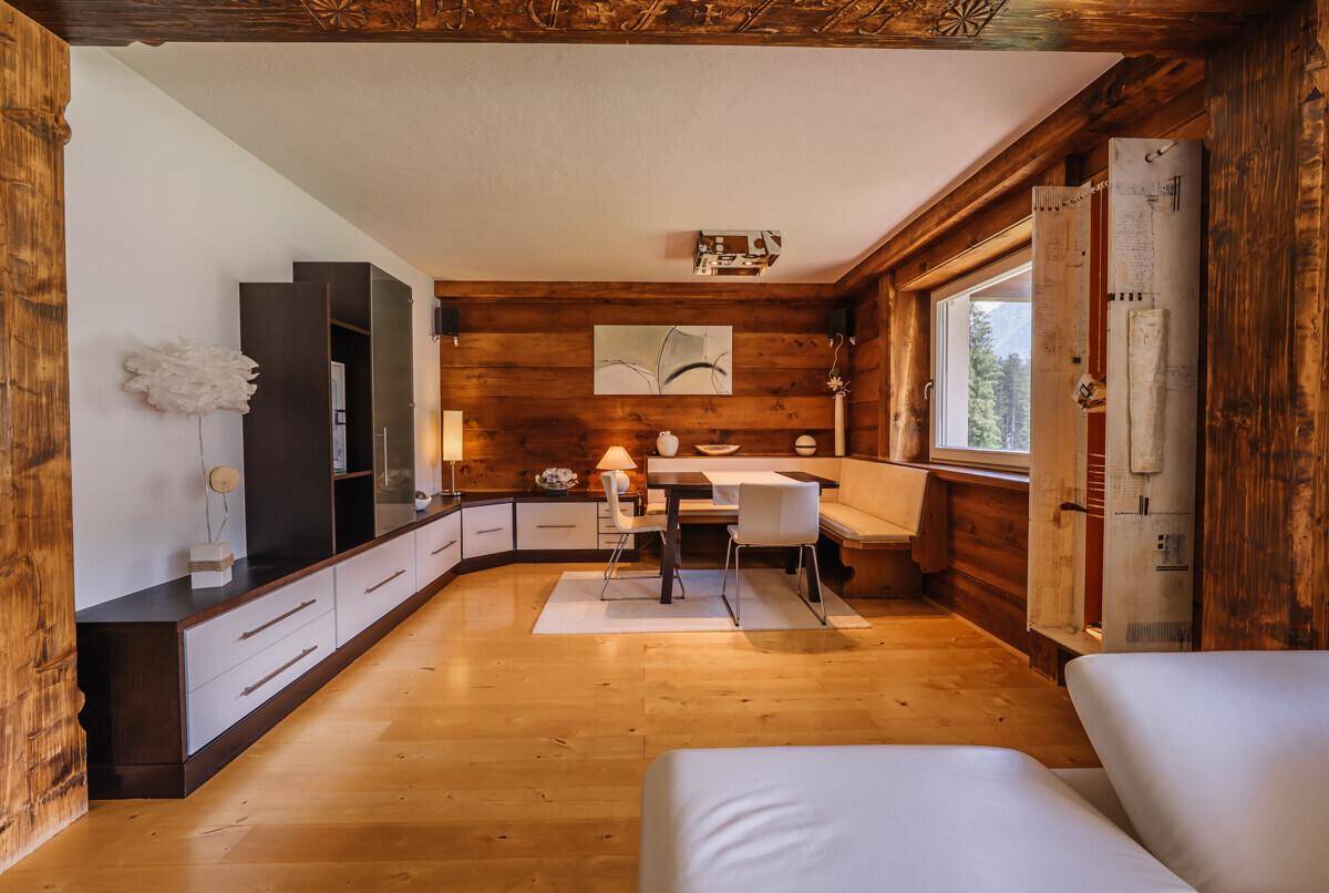 Heller Essbereich mit Holzwänden, Eckbank und modernen Möbeln im alpinen Stil.
