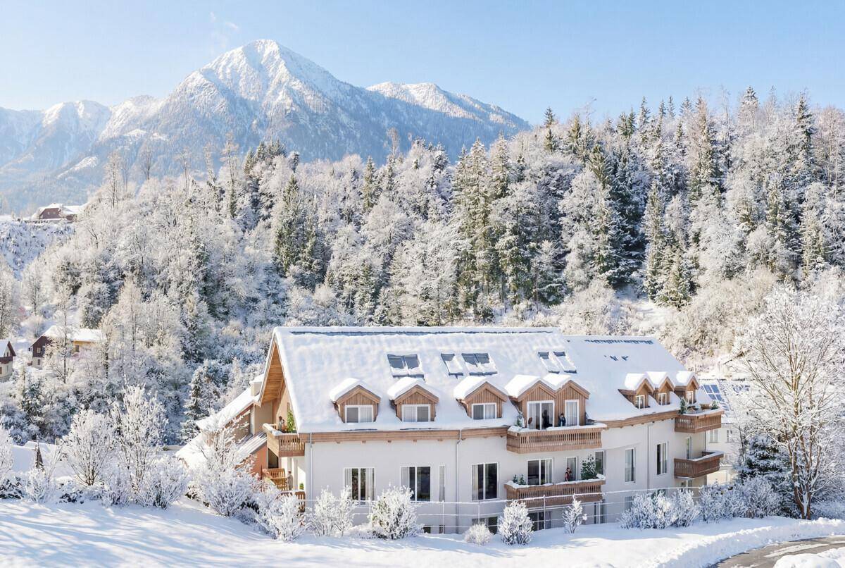 Visualisierung eines modernen Gebäudes in einer verschneiten Berglandschaft mit vielen Bäumen.