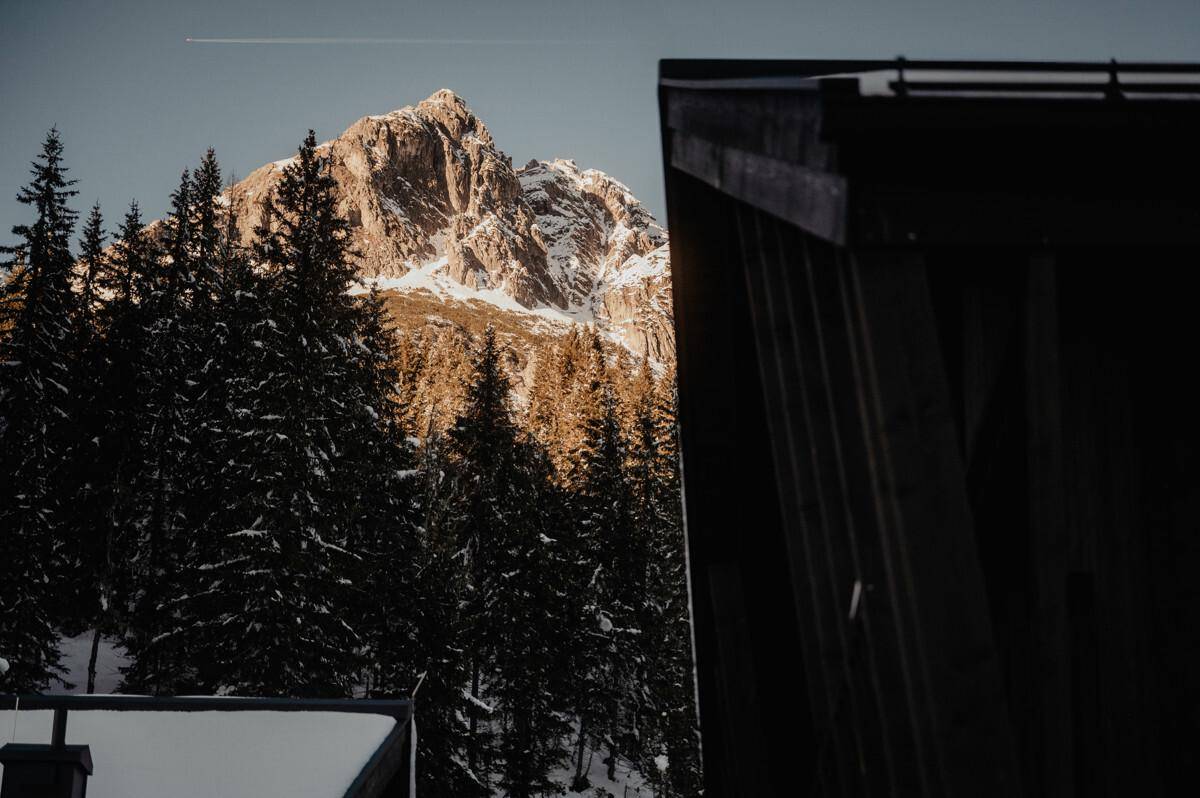 Majestätischer Bergblick über verschneite Wälder und Gipfel.
