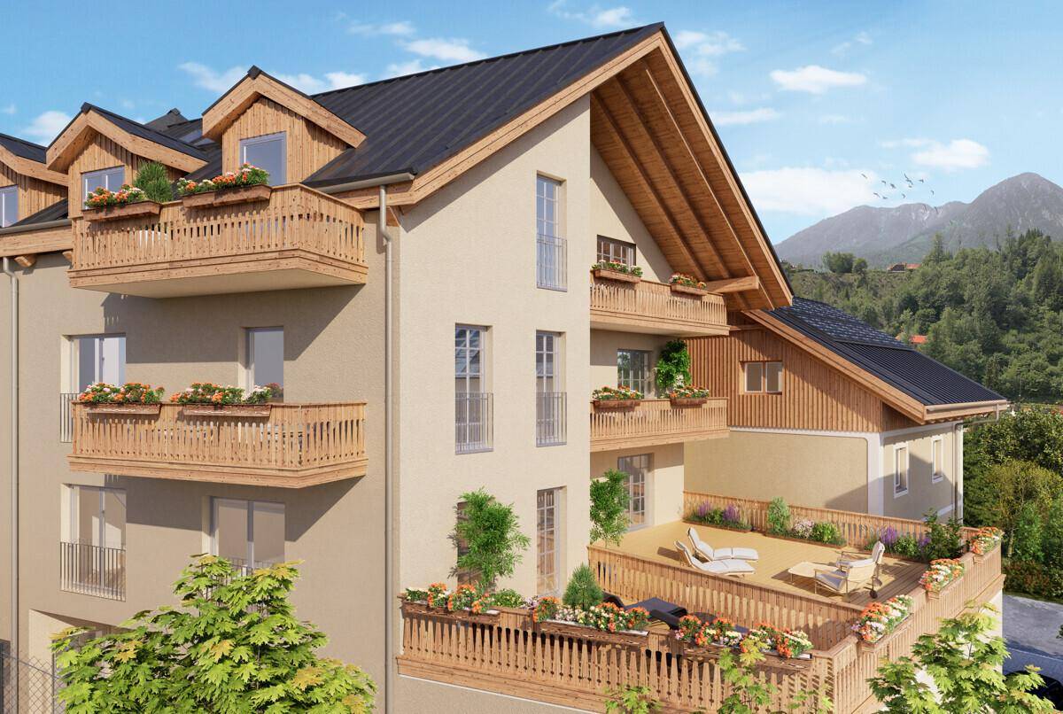 Attraktives Gebäude im alpinen Stil mit großen Balkonen und Terrassen, umgeben von Bergen.