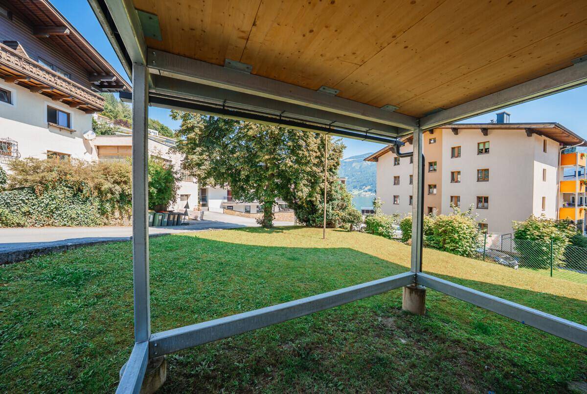 Grüner Gartenbereich mit Blick auf die umliegende Landschaft und Gebäude unter blauem Himmel.