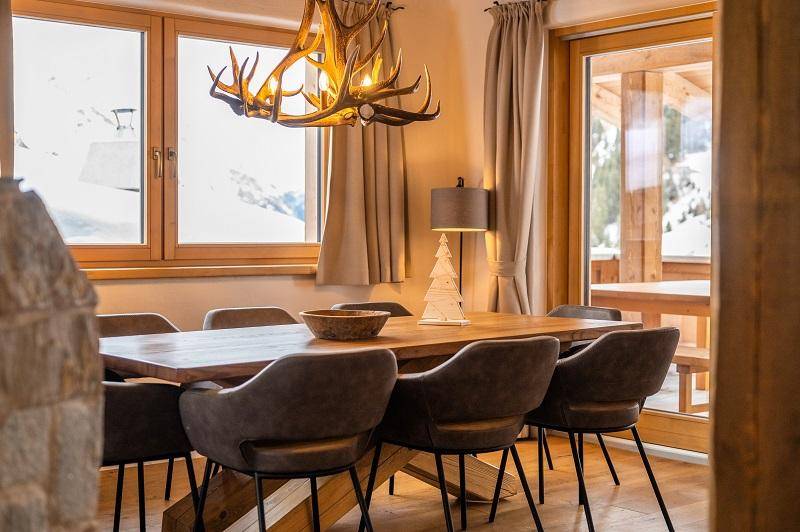 Gemütlicher Essbereich mit Holztisch, modernen Stühlen und einem Hirschgeweih-Kronleuchter.