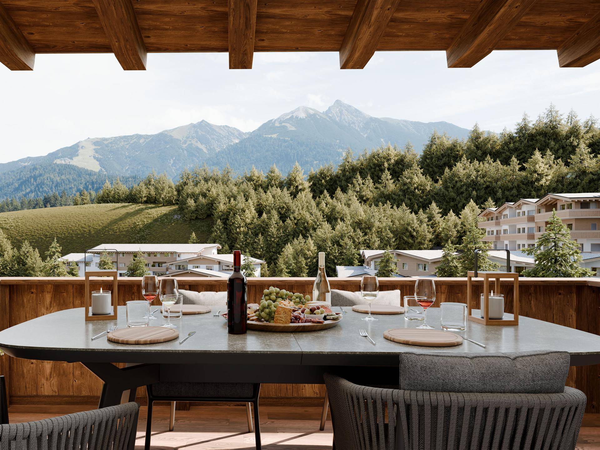 Geräumiger Balkon mit Esstisch und Stühlen, umgeben von Bergen und Wald.