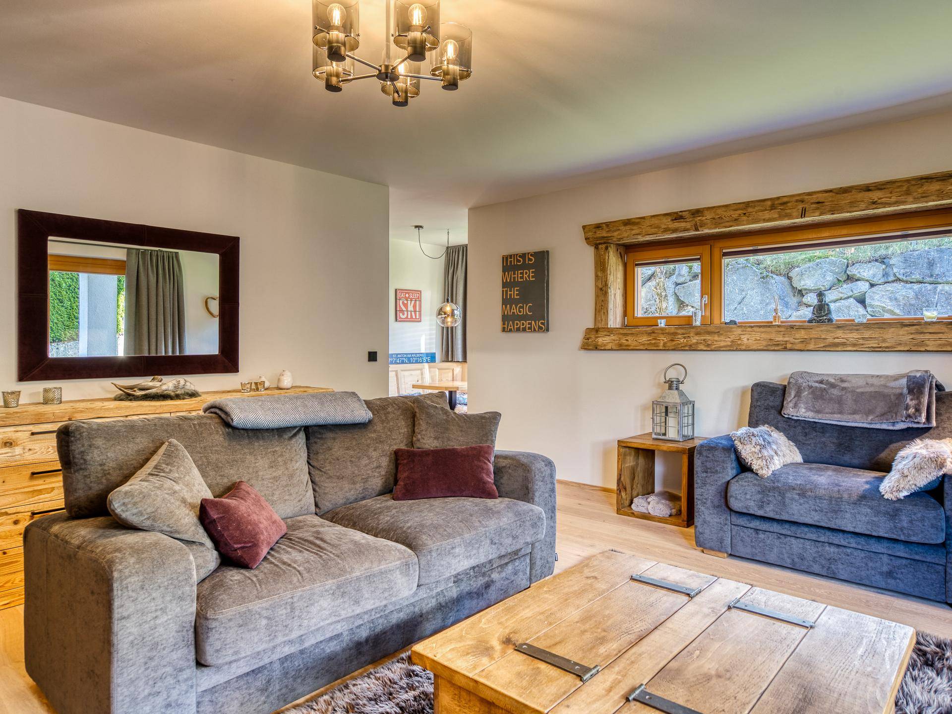 Gemütliches Wohnzimmer mit bequemer Couch, Holztisch und rustikalen Holzelementen.