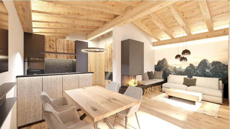 Offener Wohn-Essbereich mit Holzbalkendecke, Kamin und integrierter Küche im alpinen Stil.