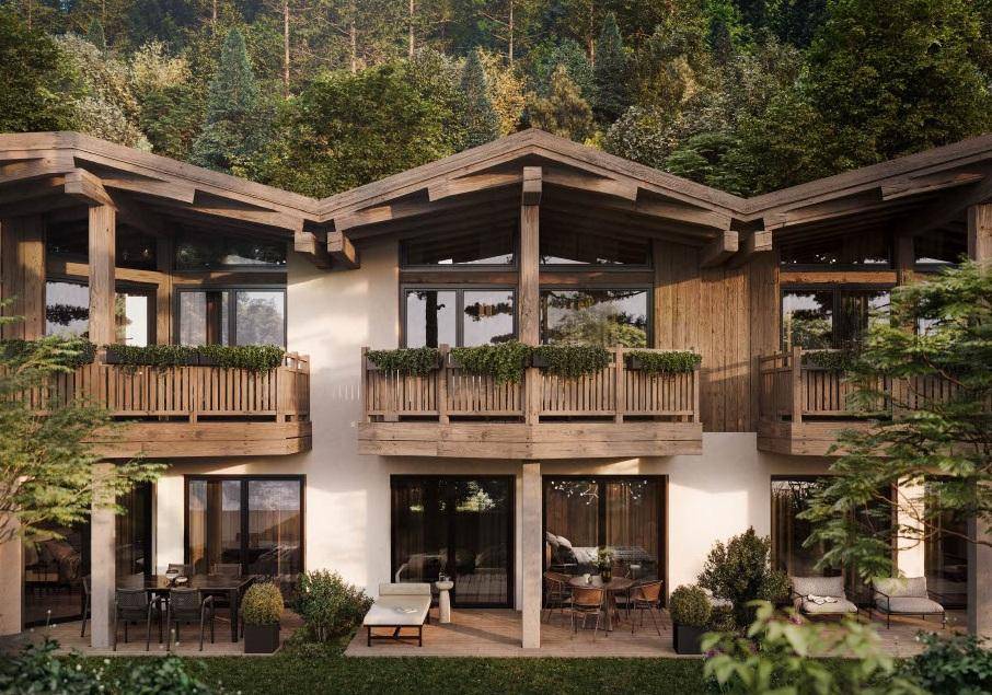 Moderne alpine Architektur mit Holzfassade, Balkonen und möblierten Terrassenbereichen.