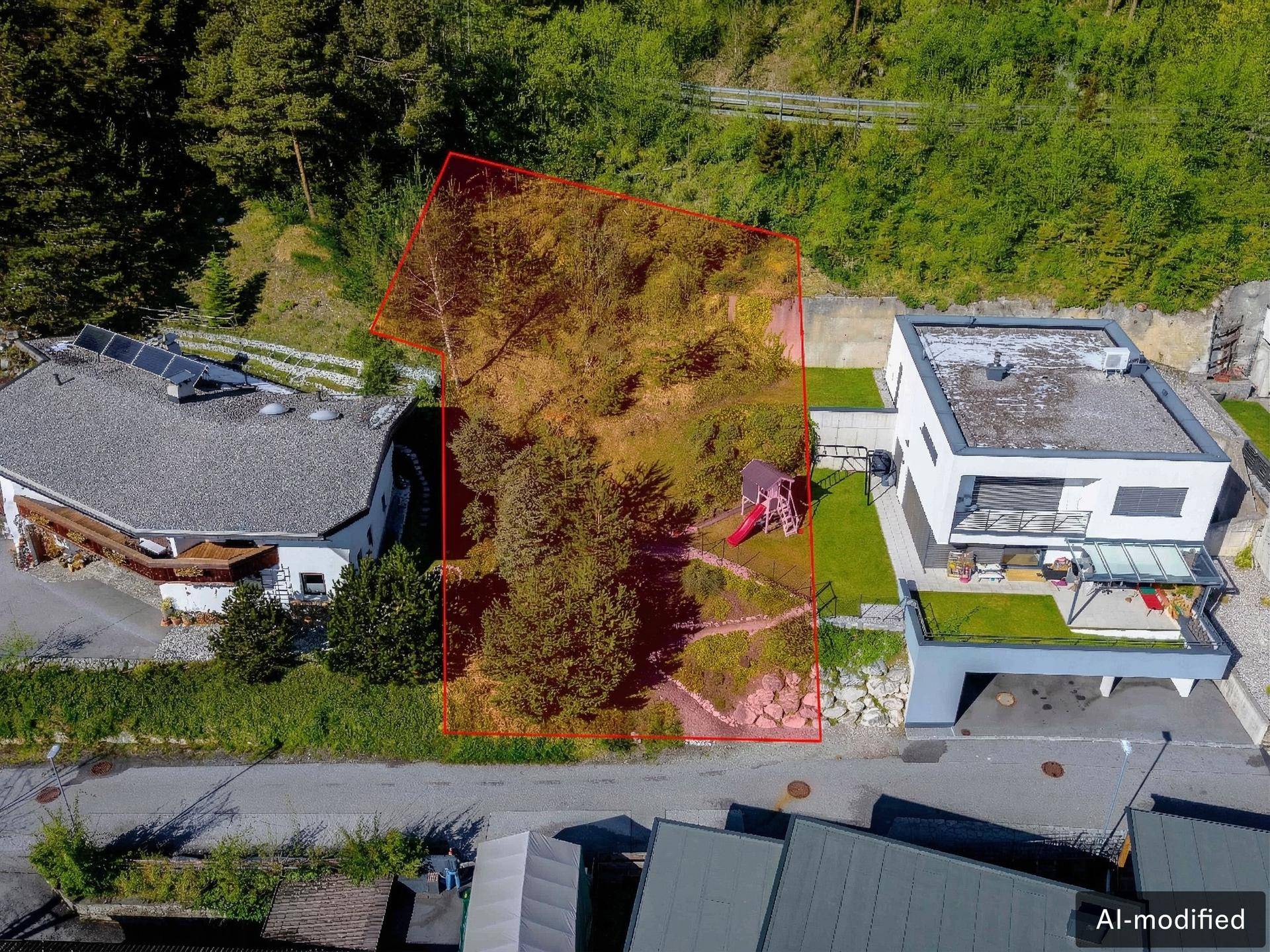 Luftaufnahme eines Grundstücks mit roter Markierung, angrenzend an ein Haus mit Garten und Wald.