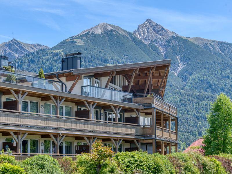 Attraktives Gebäude mit moderner Architektur, Holzdetails und beeindruckendem Bergblick.