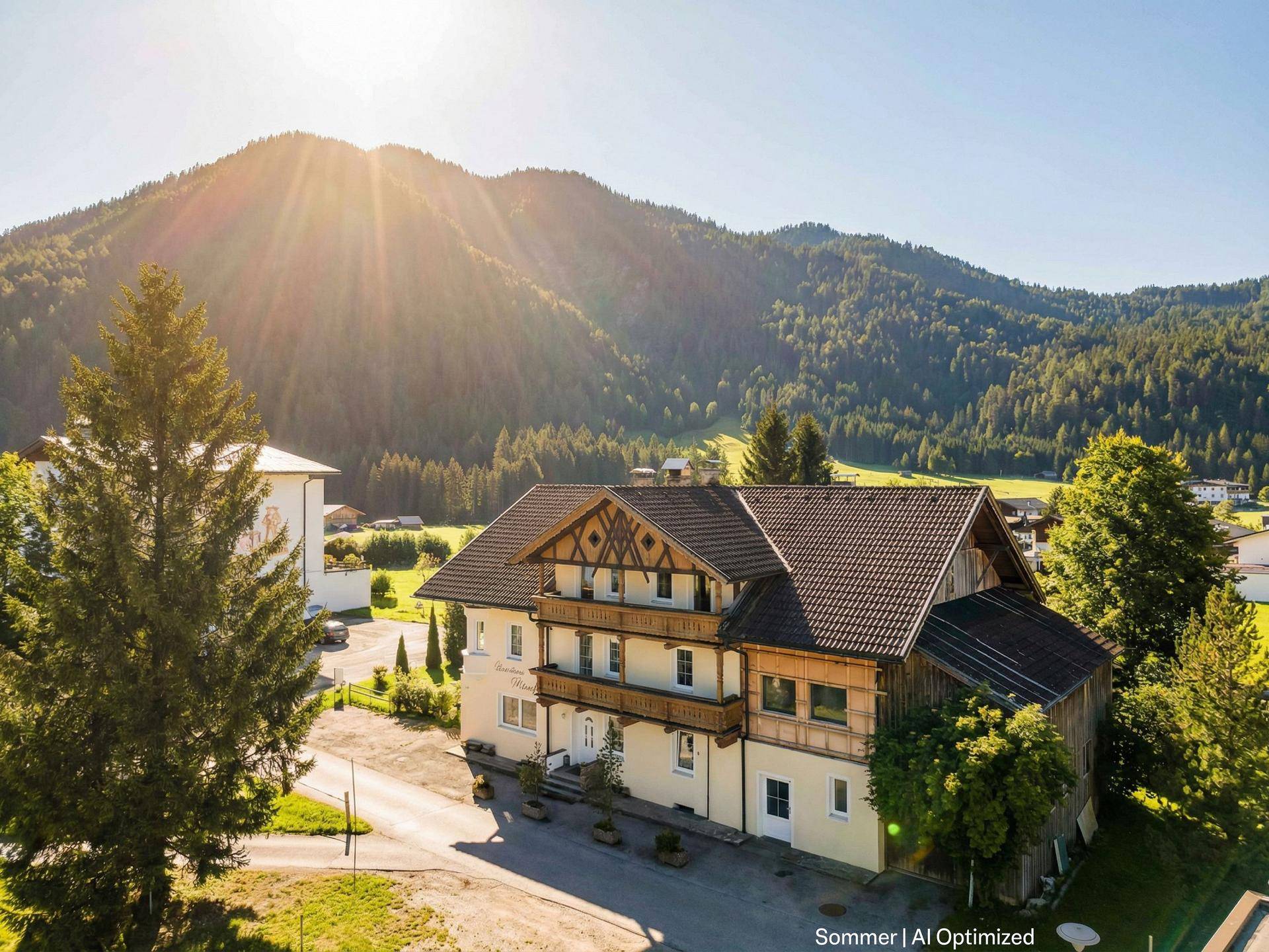 Traditionelles Gebäude in den Bergen mit Holzbalkonen und sonniger Umgebung.