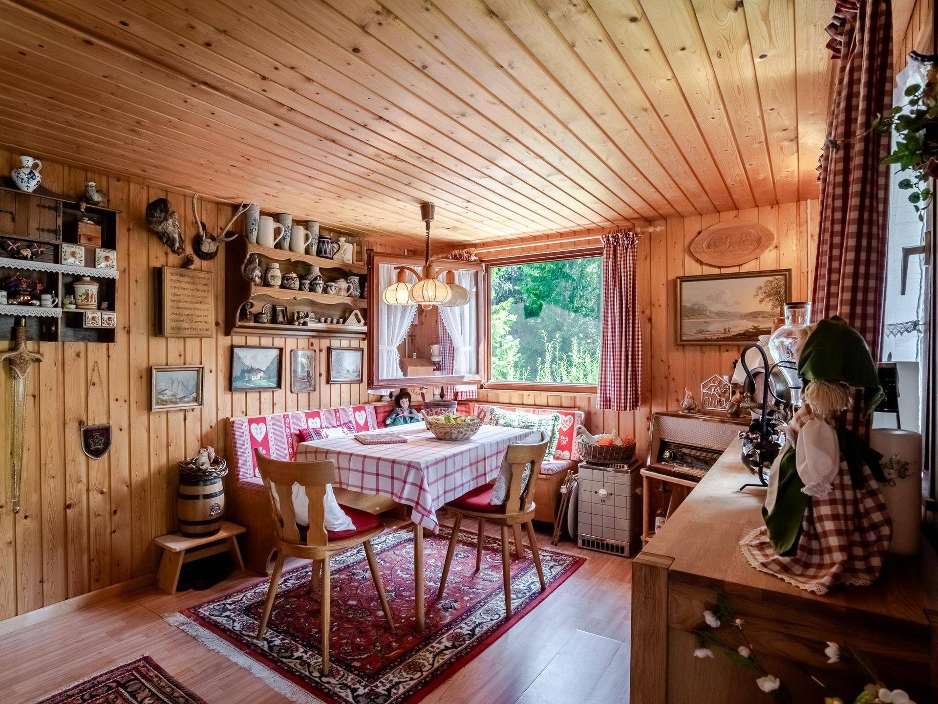 Gemütlicher Essbereich mit Holzvertäfelung, Eckbank und traditioneller Dekoration.