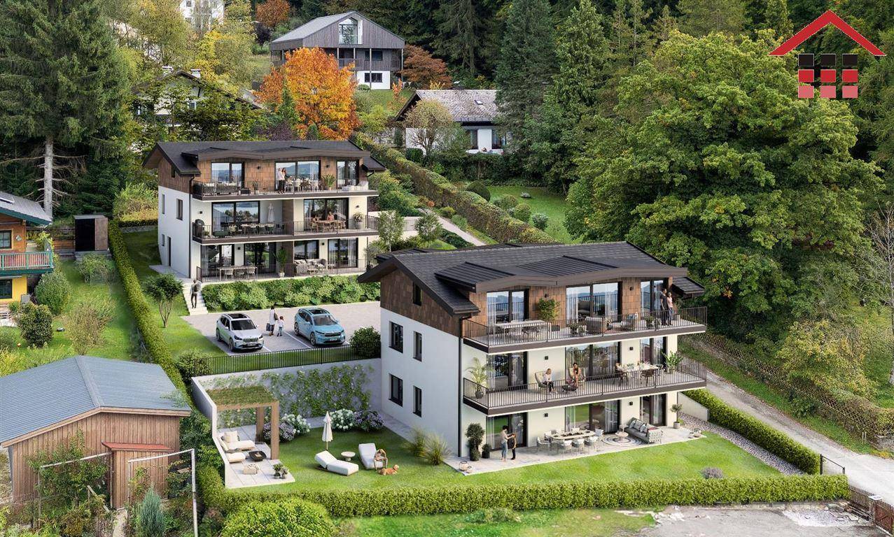 Moderne Mehrfamilienhäuser in Hanglage mit Balkonen und umliegender Natur und Bäumen.