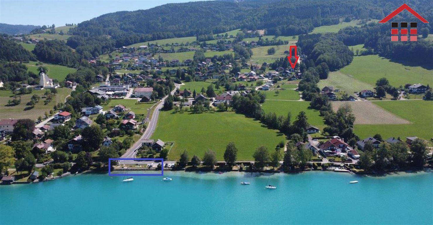 Luftaufnahme der Immobilie in idyllischer Lage direkt am See mit umliegender grüner Landschaft.