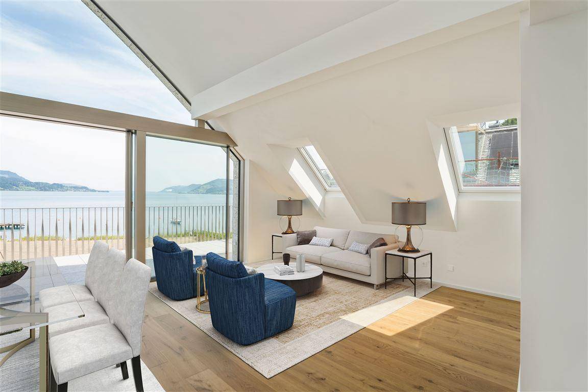 Lichtdurchflutetes Wohnzimmer mit Seeblick, großen Fenstern und moderner Einrichtung.