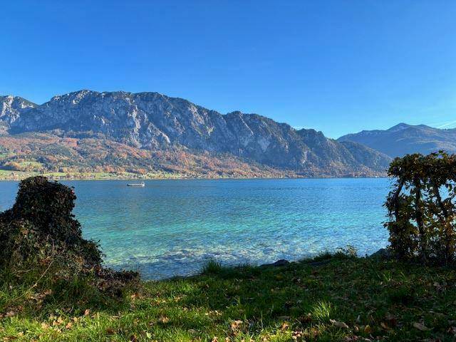 Idyllischer Blick auf den See und die umliegenden Berge an einem klartag mit herbstlicher Färbung.